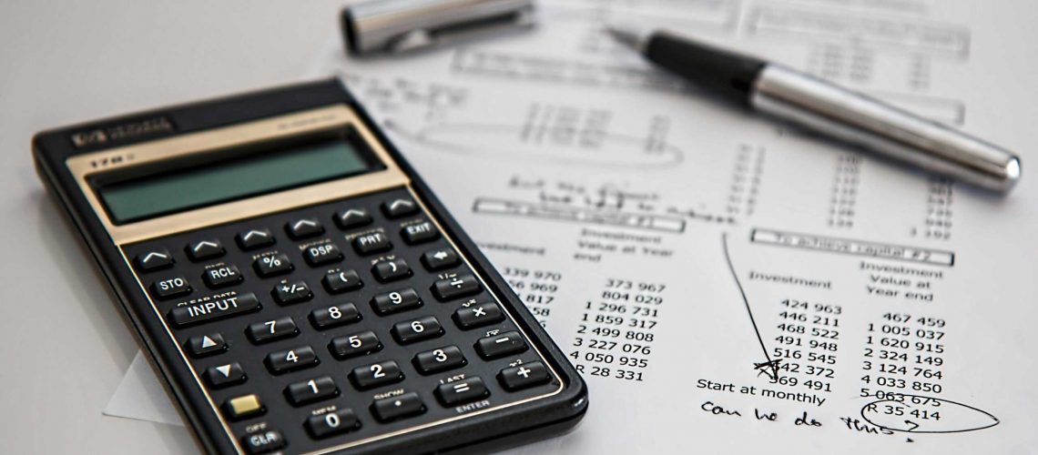 Close-up of financial documents with calculator and pen, ideal for business management themes.