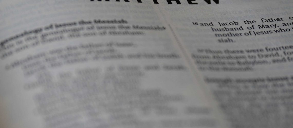 Close-up of an open Bible showing the Book of Matthew with selective focus.